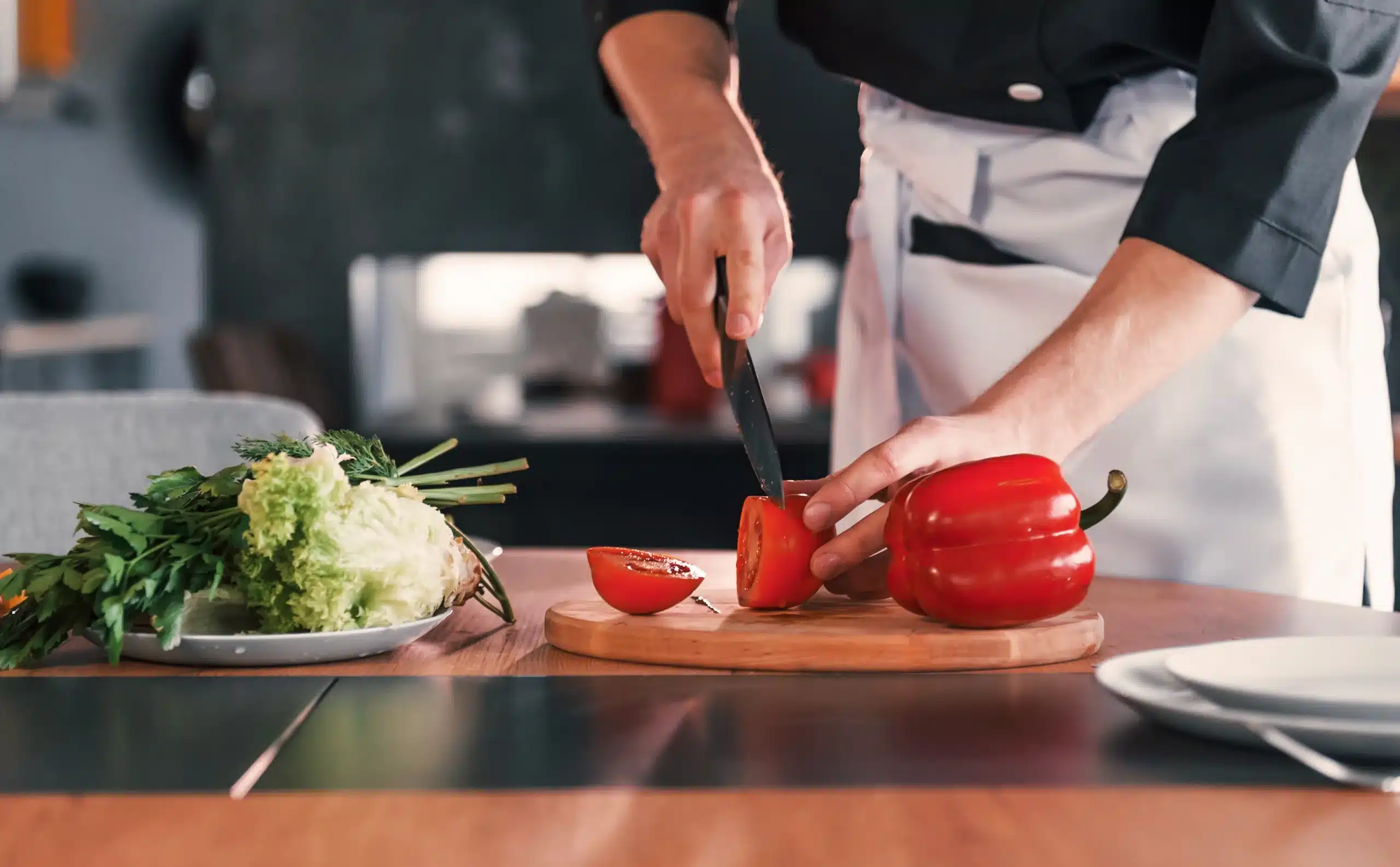 Homem cortando um tomate.